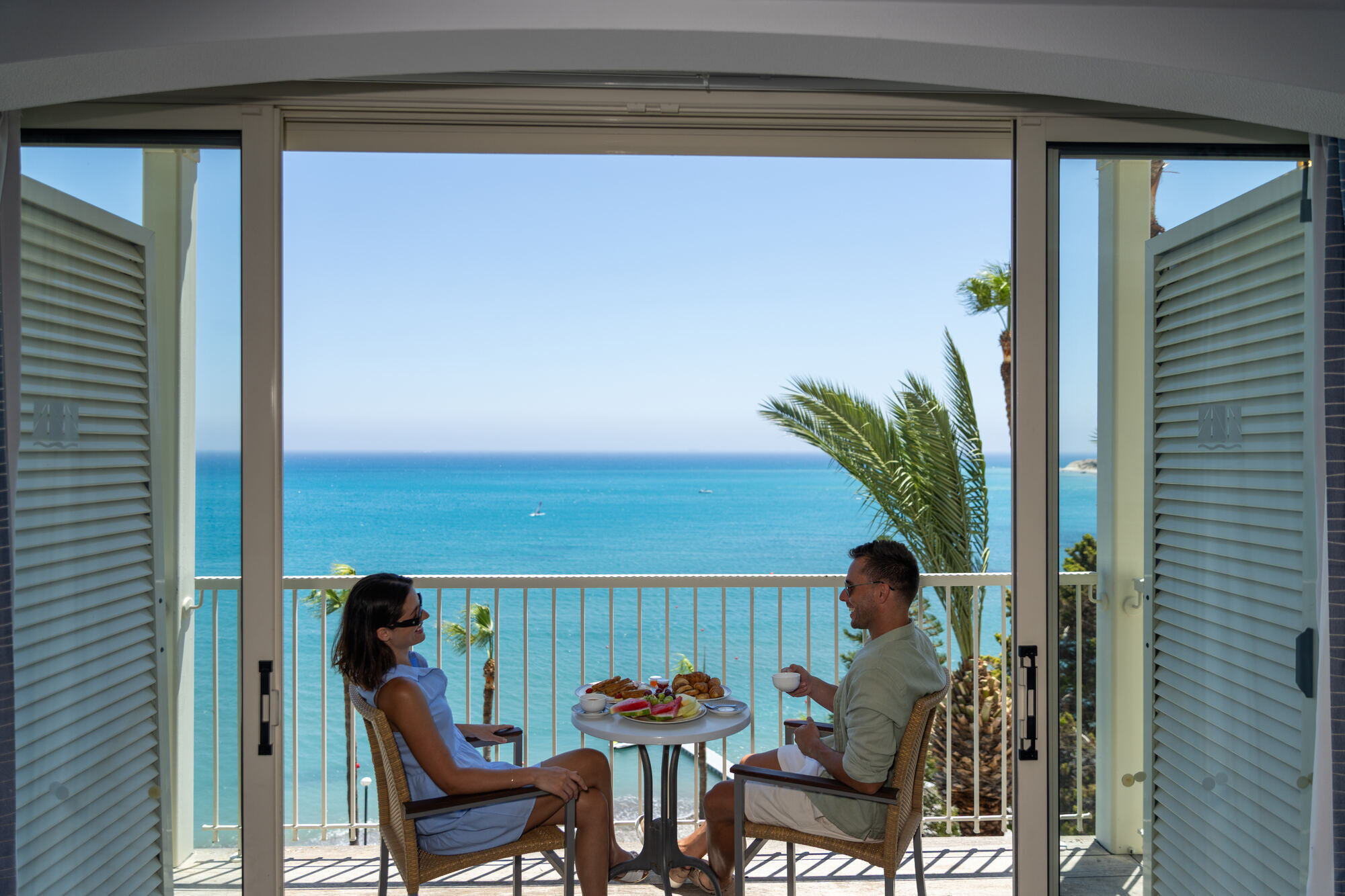 Guests on a suite balcony with sea view